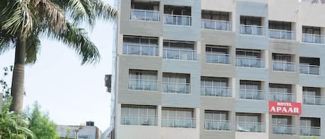 A multi-story hotel building with a sign indicating 'Hotel APAAR' and a restaurant below.