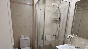 A bathroom with a glass-enclosed shower, a toilet, and a sink with a mirror. - Vacation Apartment 'Terraza del Atlántico' with Sea View and Wi-Fi (Santa Cruz de Tenerife)