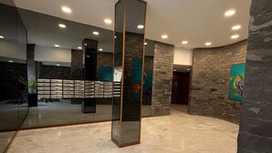 A spacious lobby with a marble floor, a tall mirror, and stone walls. - Vacation Apartment 'Terraza del Atlántico' with Sea View and Wi-Fi (Santa Cruz de Tenerife)