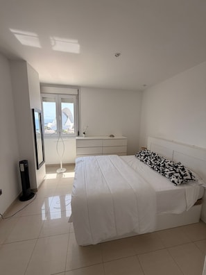 Una camera da letto con un letto, una cassettiera, una televisione e una finestra vista.
