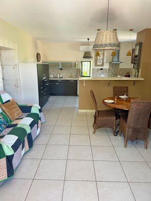 A living room with a sofa and a dining area with a table and chairs. - At YVETTE's (Saint-Rémy-de-Provence)