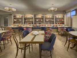 A library-style seating area with bookshelves, tables, and chairs.