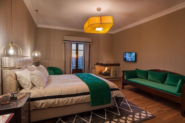 A hotel room with a bed, a sofa, a television, and a fireplace. - Ef Zin Studios and Suites (Distomo-Arachova-Antikyra)