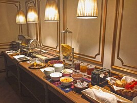 Montaje de bufé con diferentes opciones de comida y una máquina de café.