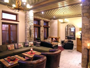A cozy lounge area with a stone wall, a fireplace, and comfortable seating. - Ef Zin Studios and Suites (Distomo-Arachova-Antikyra)