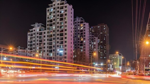 A nighttime cityscape with high-rise buildings and light trails from moving vehicles. - Gem Hefei Qianshan North Road Phoenix Hotel (Hefei)