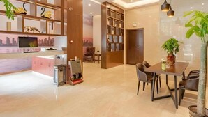 A modern hotel lobby with a reception desk, seating area, and a large bookshelf. - Gem Hefei Qianshan North Road Phoenix Hotel (Hefei)
