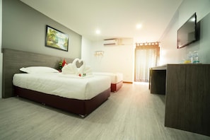 A hotel room with a large bed, a desk, a television, and a painting on the wall. - NK Residence Sakon Nakhon (Sakon Nakhon)