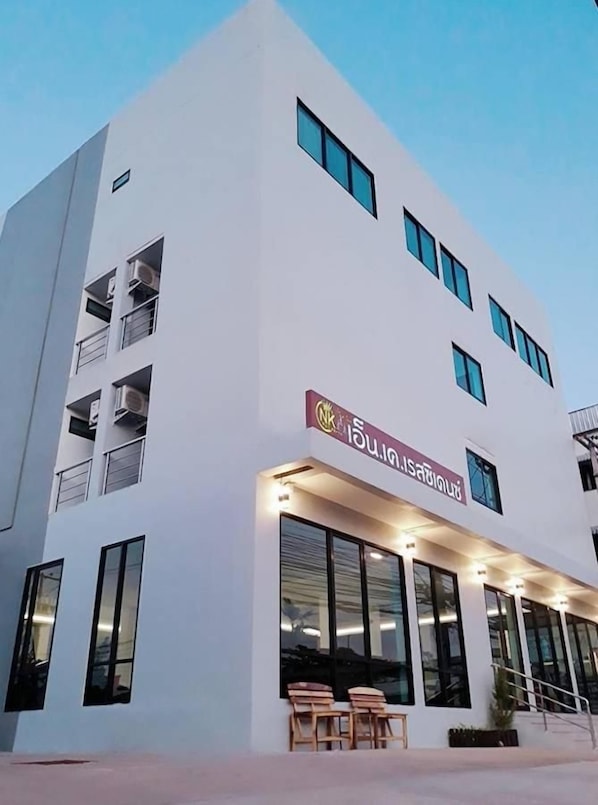 A modern building with a flat facade, large windows, and a sign with text. - NK Residence Sakon Nakhon (Sakon Nakhon)