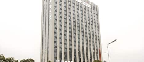 A tall, multi-story hotel with a prominent entrance and signage.