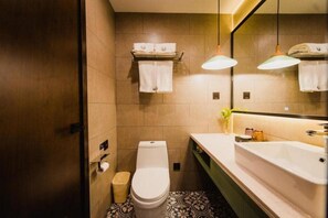 Une salle de bain moderne avec des toilettes, un lavabo et un miroir.