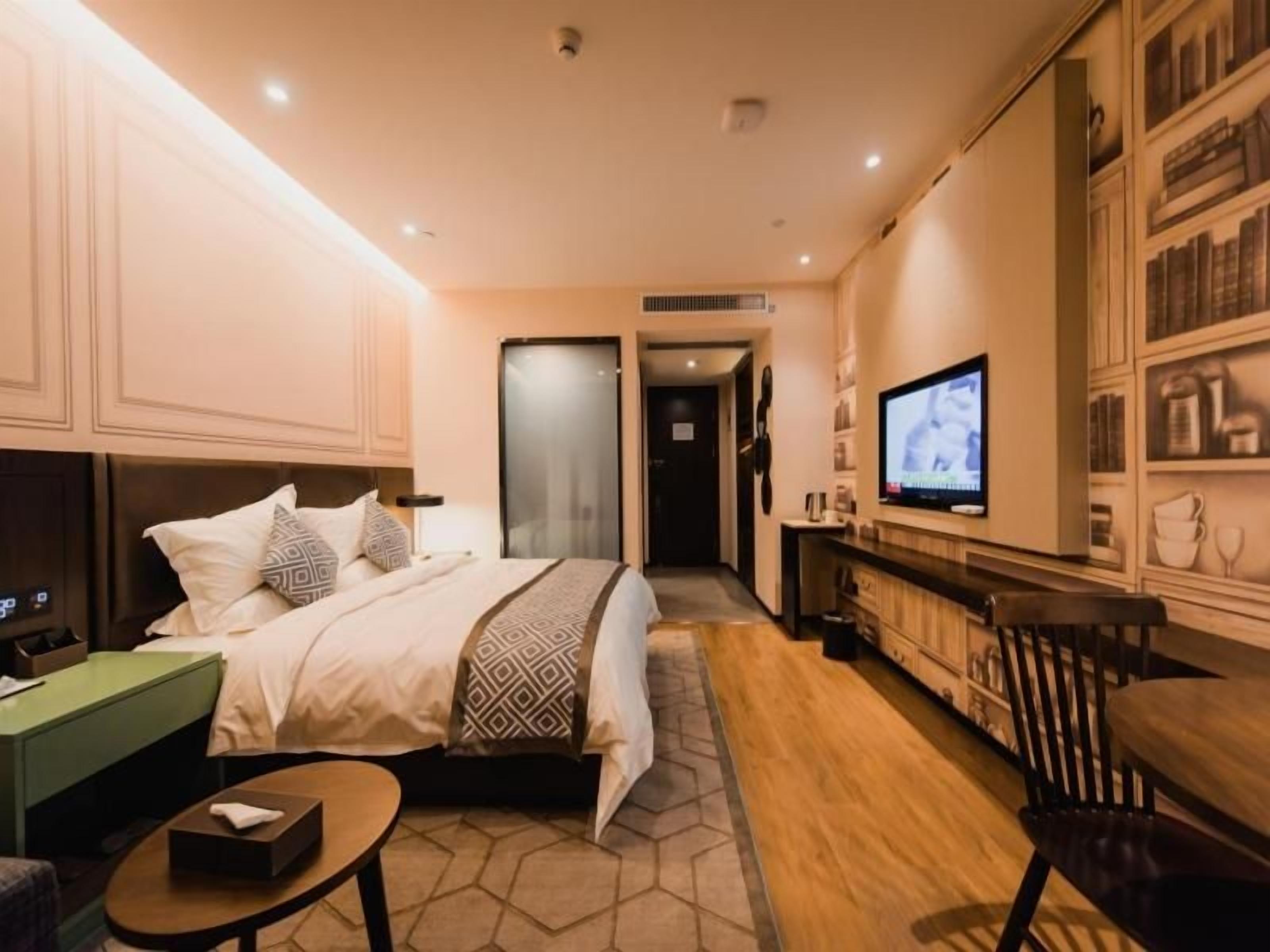 Une chambre d’hôtel avec un lit, une télévision, un bureau et une bibliothèque.