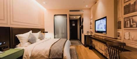Une chambre d’hôtel avec un lit, une télévision, un bureau et une bibliothèque.