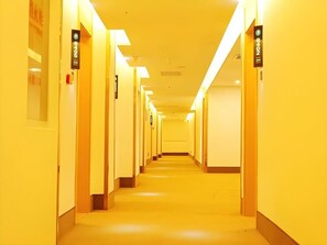 A long, narrow hallway with doors on both sides, each marked with a number.