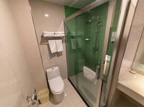 A modern bathroom with a glass-enclosed shower, a toilet, and a sink.