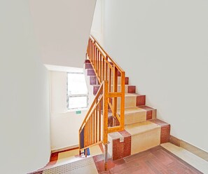 Gradi amb barana de fusta i escalons de rajola vermella que condueixen a una plataforma.