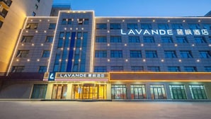 Een hotel met een moderne gevel, meerdere verdiepingen en verlichte signage.