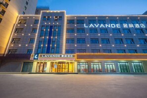 Un hôtel doté d’une façade moderne, de plusieurs étages et d’une enseigne lumineuse.