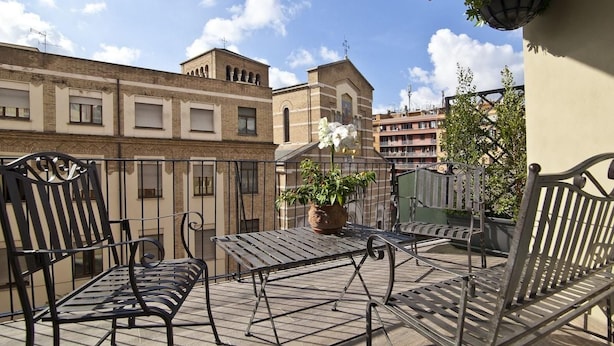 A balcony with a metal table and chairs, a potted plant, and a hanging light fixture. - Lavande Hotel (Tianjin)
