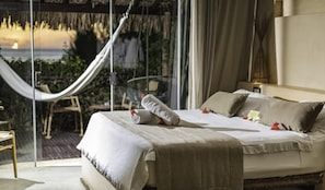 A bedroom with a bed, pillows, a bedside table, and a view of the outdoors. - Casa de Areia Jeri (Jijoca de Jericoacoara)