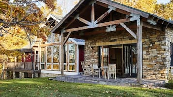 A stone building with a wooden porch and a covered outdoor seating area.
