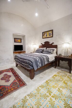 A bedroom with a bed, a bedside table, a TV, and two wall-mounted lamps. - Casa Wabi Sabi - Peceful Oasis - 3 bed 3 bath 1 pool - La Ermita, Merida, Centro (Mérida)