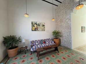 A room with a patterned floor, a sofa, two hanging lights, a potted plant, and a painting on the wall. - Casa Wabi Sabi - Peceful Oasis - 3 bed 3 bath 1 pool - La Ermita, Merida, Centro (Mérida)
