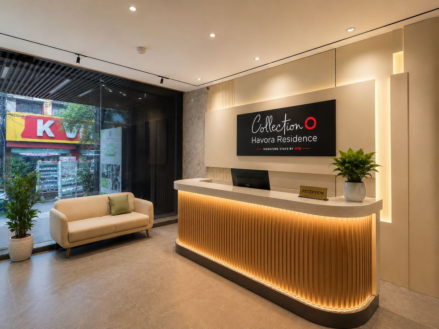 Un mostrador de recepción de hotel con diseño moderno, un letrero que dice 'Collection Havora Residence' y un sofá al frente.