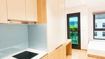 Quarto moderno com cama, escrivaninha embutida e vista para o exterior.
