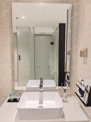 Une salle de bain avec un grand miroir, deux lavabos et un porte-serviettes.