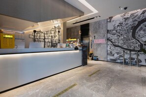 A modern hotel reception area with a marble floor, a reception desk, and a wall-mounted map. - Echarm Hotel Guangzhou Tianhe Gangding Metro Station Shipai Dong Road (Guangzhou)