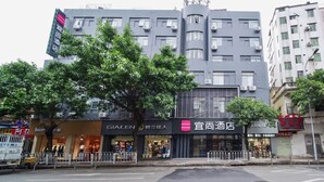 Un hotel con fachada moderna, varios pisos y un letrero llamativo.