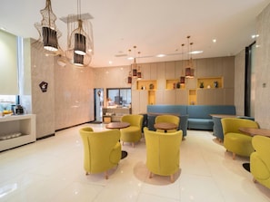 A modern interior with yellow chairs, round tables, and pendant lighting. - Echarm Hotel Guangzhou Tianhe Gangding Metro Station Shipai Dong Road (Guangzhou)