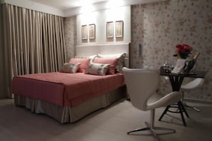Une chambre à coucher avec un lit, une chaise, un bureau et une table de chevet.
