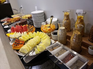 Un buffet proposant une variété d’aliments, notamment des fruits, des légumes et des céréales.