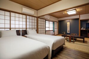 A traditional Japanese-style room with two beds, a wooden floor, and a tatami mat area. - Izunagaoka Onsen Kobo no Yu Nagaokaten (Izunokuni)