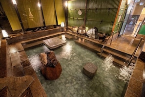 A traditional Japanese onsen with stone baths, a wooden bench, and a lantern. - Izunagaoka Onsen Kobo no Yu Nagaokaten (Izunokuni)