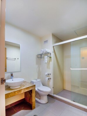 A bathroom with a sink, toilet, and glass-enclosed shower. - Capital O Hotel Herederos, Piedras Negras (Piedras Negras)