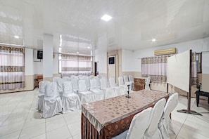 A conference room with a long table, chairs, and a podium.