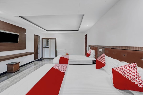 A modern hotel room with a large bed, a TV, and a bathroom visible in the background.