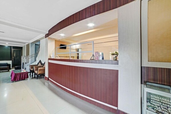 A reception area with a counter, seating, and a staircase.