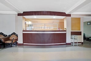 Zona de recepción con mostrador, sofá y una pequeña mesa.