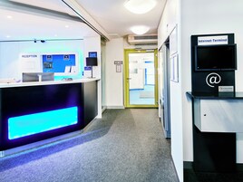 A reception area with a reception desk, a computer monitor, and a sign for the Internet- terminal.