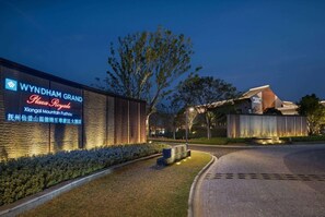 A hotel entrance with a signboard, a landscaped area, and a building structure. - Wyndham Grand Plaza Royale Xiangai Mountain Fuzhou (Fuzhou)