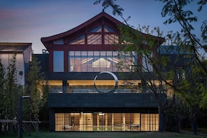 Un bâtiment moderne doté d’une architecture remarquable, notamment grâce à sa toiture originale, et d’un grand logo circulaire.