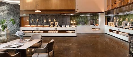 A modern kitchen with a central island, pendant lighting, and a stone backsplash.