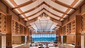 Un'ampia hall con soffitto alto, ampie finestre e un lampadario centrale.
