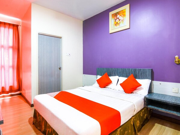A hotel room with a bed, a door, a window with curtains, and a painting on the wall. - OYO 43930 Hotel Esplanade (Sandakan)