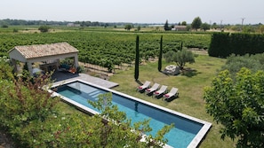 A swimming pool with lounge chairs, a covered seating area, and vineyard in the background. - 8-person Ventoux view villa in the heart of the vineyards (Caromb)