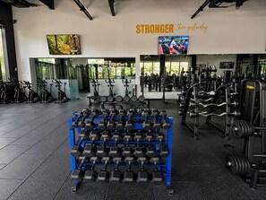 Une salle de sport équipée de matériel d’exercice, notamment des haltères et des tapis de course.